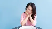 Potret seorang perempuan menahan lapar setelah mengonsumsi makanan dietnya. (Foto dok: Freepik/timeimage).