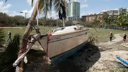 Sebuah kapal terhempas ke daratan akibat terhempas badai Irma di Coconut Grove, Florida, Senin (11/9). Badai Irma menghantam negara bagian Florida dengan kecepatan angin mencapai 200 km/jam. (SAUL LOEB/AFP)