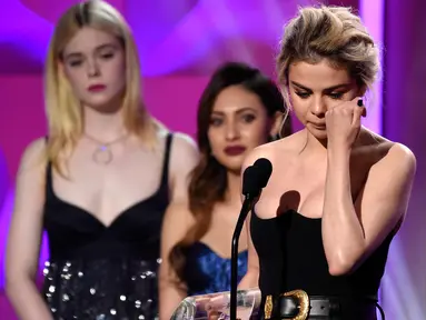 Penyanyi Selena Gomez menyeka air mata usai menerima penghargaan  Woman of the Year di atas panggung di Billboard Women In Music 2017 di Ballroom Ray Dolby di Hollywood & Highland Center di Hollywood, California (30/11). (AP/Chris Pizzello)
