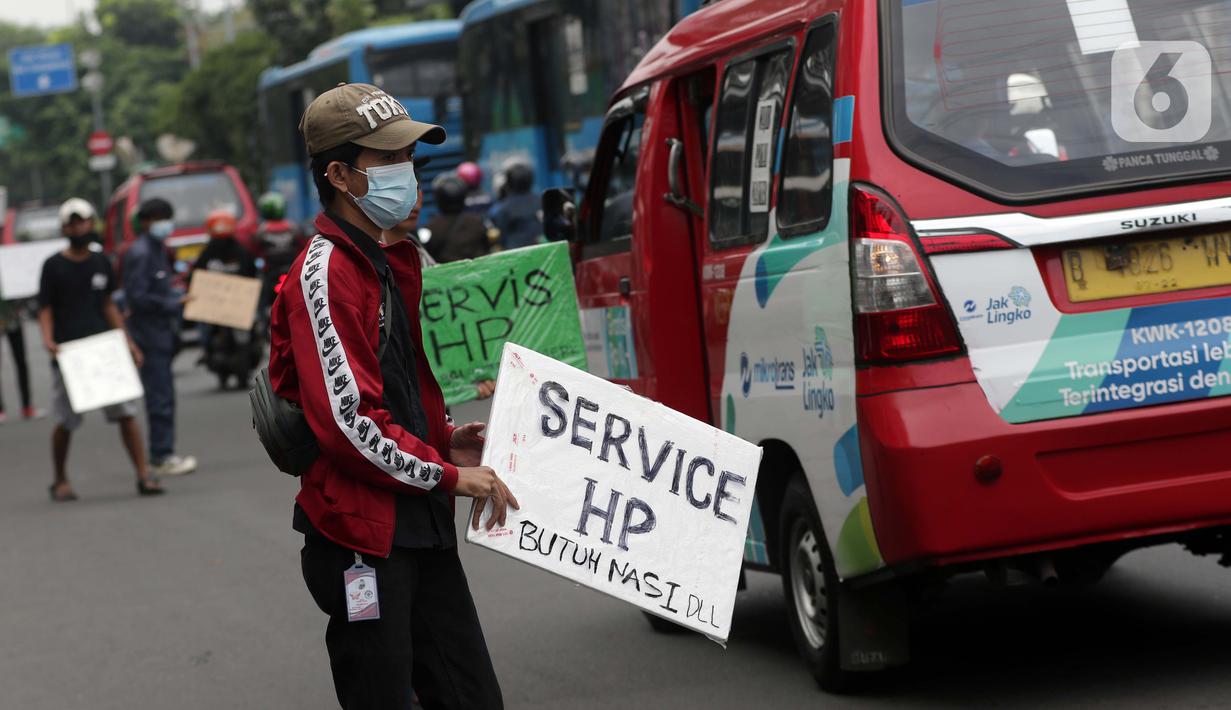 Penjual jasa perbaikan telepon genggam menawarkan jasa di pinggir jalan Mayjen Sutoyo depan Mall Pusat Grosir Cililitan (PGC), Jakarta, Rabu (14/7/2021). Imbas dari penutupan Mall PGC selama PPKM Darurat Jawa-Bali, mereka terpaksa menawarkan jasa di pinggir jalan. (Liputan6.com/Helmi Fithriansyah)