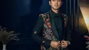 Arya Saloka tampil menawan dengan jas hitam beraksen batik dari Wong Hang Tailor lengkap dengan inner kemeja dan dasi kupu-kupunya, dipadukan celana hitamnya. [@netflixid]