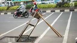Kendaraan melintas di samping bekas galian proyek yang tidak tuntas pengerjaannya di Jalan Margonda Raya, Depok, Jawa Barat, Kamis (9/5/2019). Kondisi jalan yang diabaikan selama beberapa bulan terakhir tersebut memersempit dan mengganggu aktivitas warga. (Liputan6.com/Immanuel Antonius)