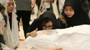 Istri anak bergantian mencium jenazah Yockie yang telah terbujur kaku dan siap dibungkus kain kafan. (Adrian Putra/Bintang.com)