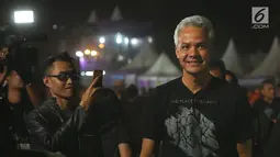 Gubernur Jawa Tengah, Ganjar Pranowo tiba untuk menonton Jogjarockarta 2018 di Stadion Kridosono Yogyakarta (27/10). Ganjar tampil seperti anak metal lainnya dengan pakaian hitam dan celana jeans. (Fimela.com/Bambang E.Ros)