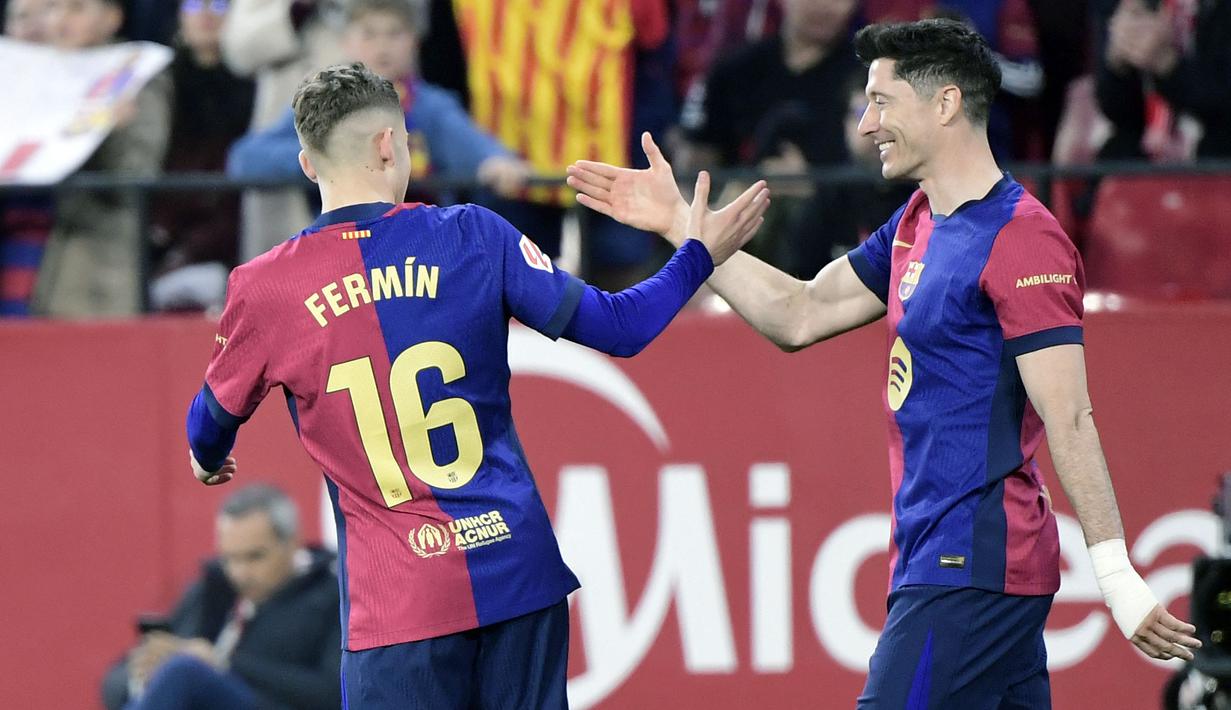 Pemain Barcelona, Fermin Lopez merayakan gol bersama Robert Lewandowski dalam laga lanjutan Liga Spanyol 2024/2025 melawan Sevilla di Ramon Sanchez Pizjuan Stadium, Sevilla, Spanyol, Senin (10/02/2025) dini hari WIB. (AFP/Cristina Quicler)
