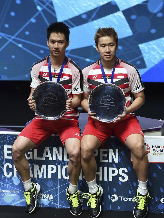 Ganda putra Indonesia, Kevin Sanjaya dan Marcus Gideon merayakan gelar All England di Birmingham, Minggu (18/3/2018). Mereka juara setelah mengalahkan Mathias Boe dan Carsten Mogensen dengan skor 21-18, 21-17. (AFP/Paul Ellis)