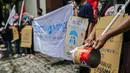 Massa Leader and Organizer of Community Organization in Asia ( LOCOA) memukul kaleng saat aksi damai di depan Kedutaan Besar Myanmar, Jakarta, Jumat (5/2/2021). Massa mengecam mundurnya demokrasi di Myanmar. (Liputan6.com/Faizal Fanani)