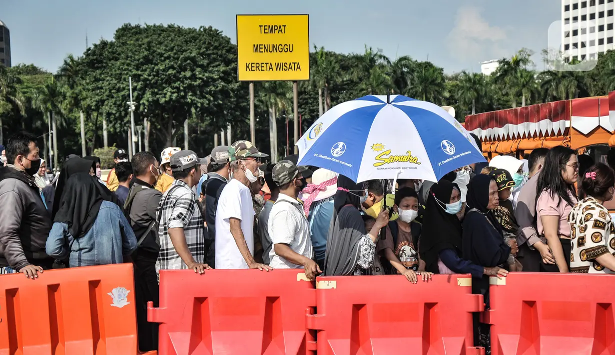 Antrean pengunjung saat menunggu fasilitas transportasi gratis yang mengantarkan ke Tugu Monas, Medan Merdeka, Jakarta Pusat, Selasa (5/7/2022). Kembali dibukanya Tugu Monas sejak Jumat (1/7) kemarin disambut antusias oleh warga baik dari dalam maupun luar Jakarta sebagai alternatif mengisi libur sekolah. (merdeka.com/Iqbal S Nugroho)