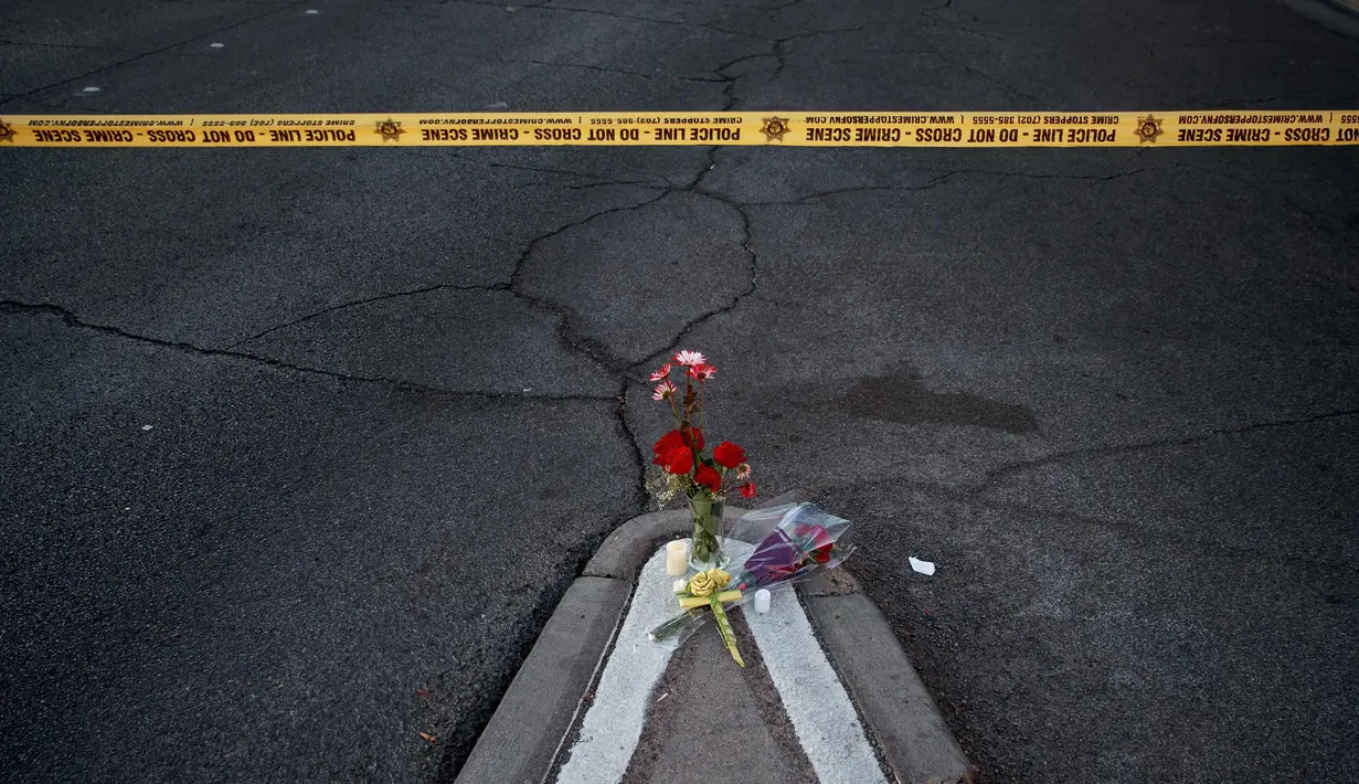 Bunga mawar merah terlihat di lokasi penembakan massal di festival musik di dekat resor dan kasino Mandalay Bay di Las Vegas (2/10). Bunga tersebut untuk korban penembakan Las Vegas yang dilakukan Stephen Paddock 64 tahun. (Drew Angerer/Getty Images/AFP)