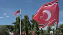 Seorang pria (kiri atas) memanjat tiang bendera saat ia berupaya mengibarkan bendera Gerakan Aceh Merdeka (GAM) bersandingan dengan bendera nasional Indonesia dalam sebuah unjuk rasa di luar Masjid Raya Baiturrahman, Banda Aceh, Provinsi Aceh, Sabtu, 15 September 2026. (AFP/ Reza Saifullah)
