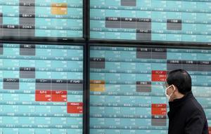 Seorang pria melihat layar monitor yang menunjukkan indeks bursa saham Nikkei 225 Jepang dan lainnya di sebuah perusahaan sekuritas di Tokyo, Senin (10/2/2020). Pasar saham Asia turun pada Senin setelah China melaporkan kenaikan dalam kasus wabah virus corona. (AP Photo/Eugene Hoshiko)