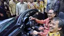 Mendag dan Menpora tersenyum bahagia saat mencicipi salah satu mobil keren di IIMS, JIEXpo, Jakarta, Kamis (18/9/2014) (Liputan6.com/Miftahul Hayat)