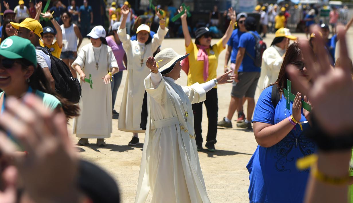 Para biarawati dan pemuda bernyanyi dan menari saat menunggu Paus Fransiskus di Gereja Maipu di Santiago, Chili (18/1). (AFP Photo / Eitan Abramovich)