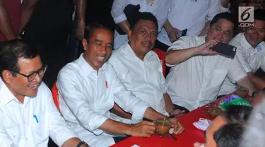 Capres nomor urut 01 Joko Widodo atau Jokowi, Politikus PDIP Pramono Anung, Gubernur Sulut Olly Dondokambey dan Ketua TKN Erick Thohir saat ngopi di Jalan Roda, Manado, Minggu (31/3). Sebelum menikmati kopi jokowi hadiri acara silaturahmi pengurus KGM dan PGI. (Liputan6.com/Angga Yuniar)