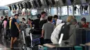 Calon penumpang pesawat memeriksa penerbangan mereka di bandara Hong Kong, Rabu (14/8/2019). Bandara Hong Kong kembali membuka penerbangan keberangkatan pada Rabu pagi setelah sempat lumpuh selama dua hari akibat demonstran menduduki salah satu bandara tersibuk di dunia tersebut. (AP/Vincent Thian)