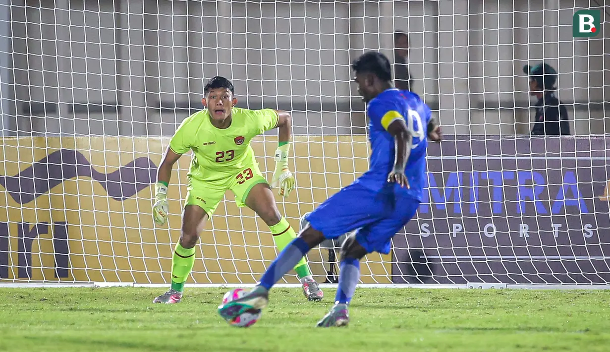 Kiper Timnas Indonesia, Ikram Al Giffari (kiri) bersiap menerima tendangan pemain Maladewa, Shanaan Rashaad pada laga Grup F Kualifikasi Piala Asia U-20 2024 di Stadion Madya, Senayan, Jakarta, Rabu (25/09/2024). (Bola.com/Bagaskara Lazuardi)