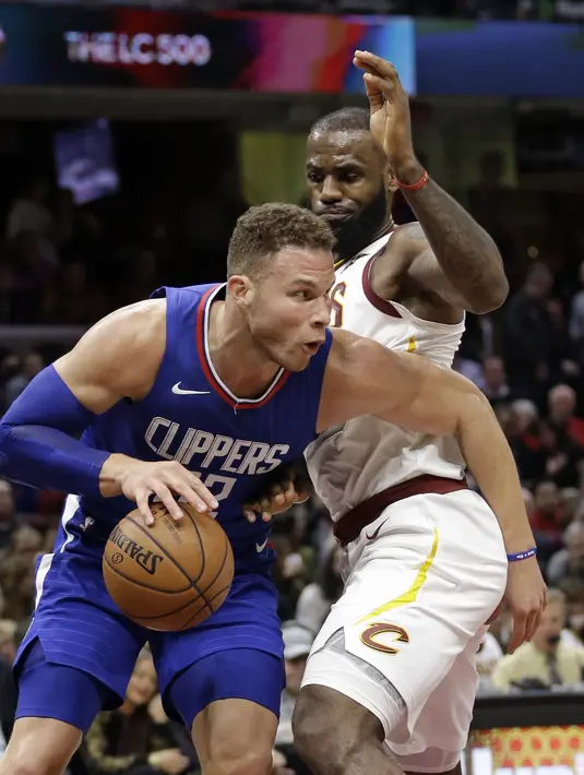 Pemain Los Angeles Clippers, Blake Griffin (kiri) berusaha melewati adangan pemain Cavaliers, LeBron James pada laga NBA basketball game di Quicken Loans Arena, Cleveland, (18/11/2017), Cavs menang 118-113. (AP/Tony Dejak)