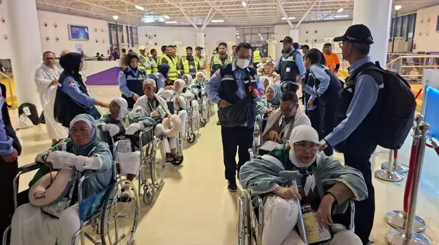 Rombongan jemaah lansia yang berkursi roda berbaris rapi masuk menuju bus khusus yang disiapkan di Bandara Internasional King Abdulaziz Jeddah pada Minggu, 18 Mei 2025. (dok. MCH 2025)