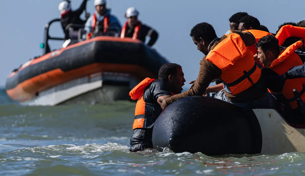 Migran berusaha menaiki perahu milik penyelundup dari pantai Equihen-Plage, Prancis utara, Rabu (23/9/2026), untuk menyeberangi Selat Inggris menuju Inggris. Pada hari yang sama, jenazah seorang pria ditemukan di Pantai Neufchâtel-Hardelot, Pas-de-Calais, setelah upaya keberangkatan sejumlah migran. Petugas pemadam kebakaran menyatakan pria tersebut meninggal dunia tak lama setelah pukul 09.00 waktu setempat. (Sameer Al-DOUMY / AFP)