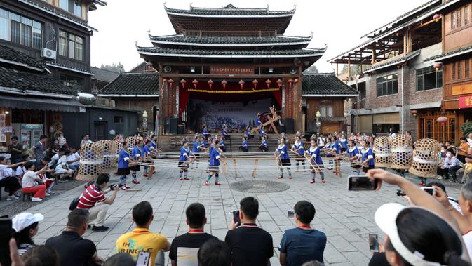 Wisatawan menyaksikan pertunjukan di sebuah kawasan wisata di Wilayah Otonom Etnis Dong Sanjiang di Kota Liuzhou, China, 2 Oktober 2020. Sejak jalur kereta cepat Guiyang-Guangzhou beroperasi pada 2014, Sanjiang telah berupaya untuk meningkatkan perekonomian melalui pariwisata. (Xinhua/Gong Pukang)
