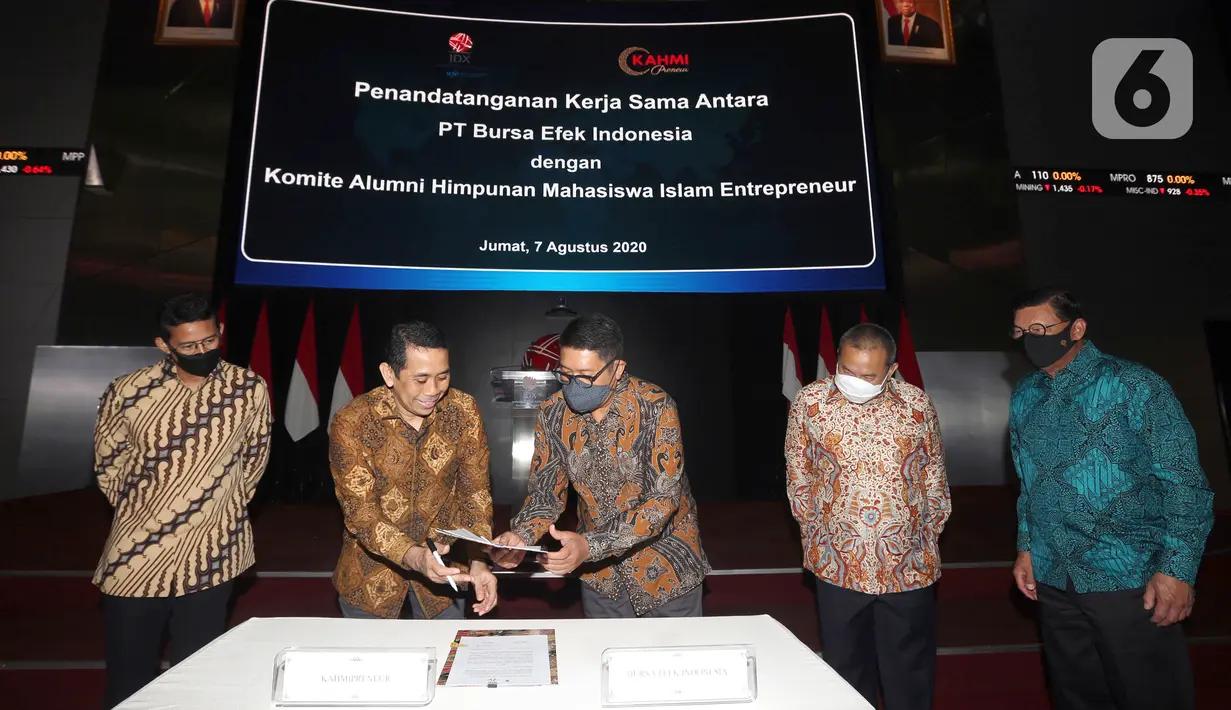 Founder KAHMIPreneur yang juga Anggota DPR Komisi XI Kamrussamad (dua kiri) dan Dirut BEI Inarno Djajadi (kanan) bertukar naskah pada penandatanganan kerja sama dalam rangka Membangun Ekonomi Anak Muda Melalui Pasar Modal di Gedung BEI, Jakarta, Jumat (7/8/2020). (Liputan6.com/Fery Pradolo)