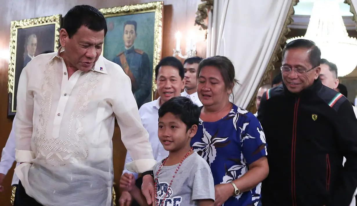 Presiden Filipina Rodrigo Duterte bersama bocah yang diculik kelompok Abu Sayyaf berada di Istana Malacanang, Manila, Filipina, Selasa (28/2). Duterte mengaku tidak ada uang tebusan untuk membebaskan bocah Filipina tersebut. (AP Photo)