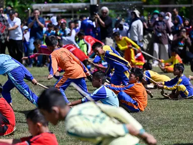 Siswa mengikuti permainan tradisional tarik upih pinang (tarek situek) pada Festival Permainan Tradisional Anak di Desa Wisata Lubok Sukon, Kecamatan Ingin Jaya, Aceh Besar, Aceh, Sabtu (25/7/2026). (AFP/ Chaideer Mahyuddin)