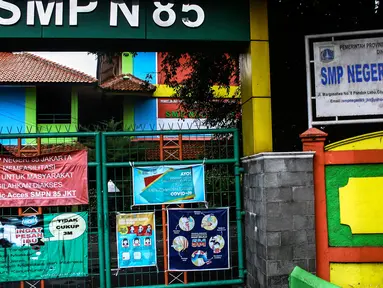 Suasana gerbang Sekolah Menengah Pertama (SMP) Negeri 85 yang ditutup di Pondok Labu, Cilandak, Jakarta, Rabu (27/7/2022). Sekolah tersebut ditutup selama 10 hari setelah tiga siswa terkonfirmasi COVID-19. (Liputan6.com/Johan Tallo)