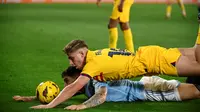 Momen pemain Celta Vigo Unai Nunez sama-sama terjatuh dengan pemain Barcelona Fermin Lopez pada pertandingan Liga Spanyol 2023/2024. (MIGUEL RIOPA / AFP)