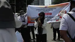Aksi ini merupakan bentuk protes terhadap diskriminasi dalam seleksi CASN/PPPK 2024, ketiadaan aturan yang menjamin keberlanjutan status kerja, serta ancaman Pemutusan Hubungan Kerja (PHK) dan peralihan ke sistem outsourcing yang semakin meluas. Tampak dalam foto, massa dari Aliansi Honorer Non Database BKN Gagal Calon Pegawai Negeri Sipil (CPNS) Indonesia saat menggelar Aksi Damai Jilid 2 Nasional di kawasan Silang Selatan Monumen Nasional, Jakarta Pusat, pada Senin (17/11/2025). (merdeka.com/magang/Rendi Saputra)