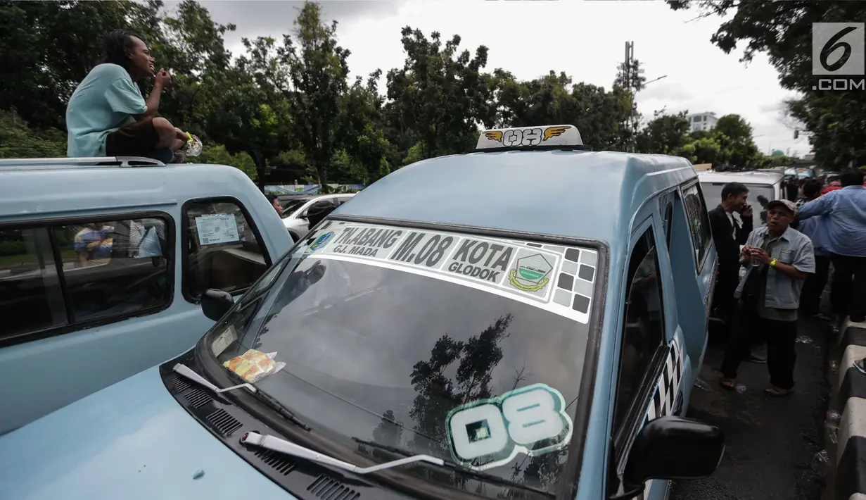 Para pengemudi angkutan memarkirkan mobilnya berkumpul untuk menggelar unjuk rasa di depan Balai Kota, Jakarta, Senin (22/1). (Liputan6.com/Faizal Fanani)