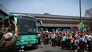 Masyarakat melambaikan tangan untuk menyambut bus yang ditumpangi pemain dan pelatih Timnas Portugal setelah memenangkan Nations League 2025 setibanya di Bandara Lisbon, Portugal, Senin (09/06/2025) waktu setempat. (AFP/Carlos Costa)