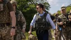 Presiden Ukraina, Volodymyr Zelensky berbincang dengan prajurit saat mengunjungi garis depan medan pertempuran dengan separatis pro-Rusia di Lugansk, Senin (27/5/2019). Zelensky meninjau posisi militer Ukraina di Stanytsya Luganska dan Shchastya. (STR/UKRAINE PRESIDENTIAL PRESS SERVICE/AFP)