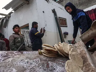 Seorang pemuda menyelamatkan roti dari sebuah rumah yang rusak, setelah pengeboman Israel di Rafah, Jalur Gaza selatan pada 25 Februari 2024. (SAID KHATIB/AFP)