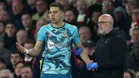 Ada momen menarik saat laga Arsenal kontra Southampton pada laga pekan ke-32 Liga Inggris 2022/2023, Sabtu (22/4/2023) dini hari WIB. Bek Southampton, Jan Bednarek bersitegang dengan tim medis yang memaksanya untuk digantikan setelah mengalami insiden horor saat ia terjatuh dengan leher mendarat terlebih dahulu usai berduel udara dengan Gabriel Martinelli jelang babak pertama usai. Setelah di bangku cadangan, Bednarek kembali berulah seolah-olah menjadi asisten pelatih dengan memberi instruksi kepada rekan-rekannya, persis seperti yang dilakukan Cristiano Ronaldo bersama Timnas Portugal. (AFP/Adrian Dennis)