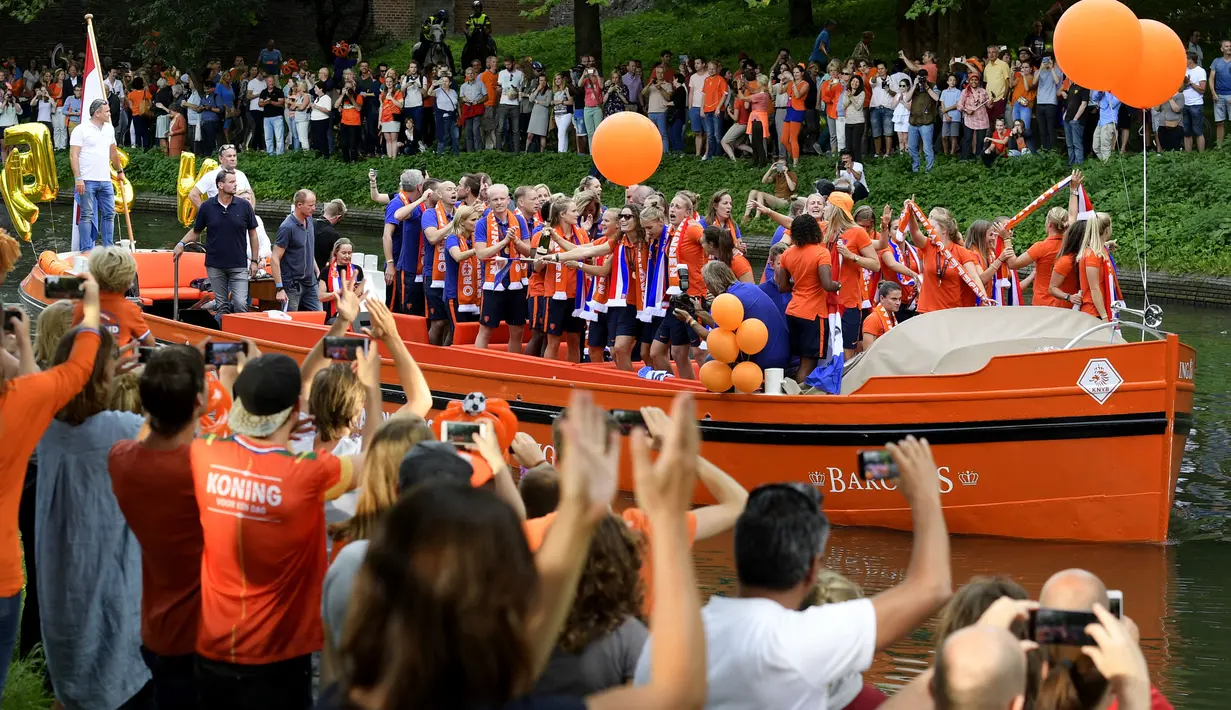 Tim sepak bola wanita Belanda merayakan kemenangannya di sebuah perahu di Utrecht, Belanda (7/9). Tim sepak bola wanita Belanda berhasil menjadi juara UEFA Women's Euro 2017 usai mengalahkan Denmark. (AFP Photo/ANP/Olaf Kraak)