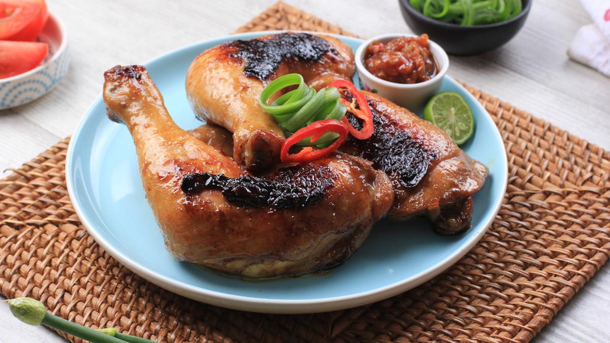 Ayam panggang madu berwarna kecokelatan mengilap, disajikan dengan taburan biji wijen dan irisan daun bawang