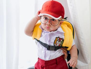 Rayyanza Malik Ahmad terkenal sebagai balita lucu yang gaya penampilannya terkenal lucu. Gaya bak anak SD ini sempat viral. Terlebih Cipung tampil lucu dengan memakai topi dan kacamata bak seorang kutu buku. (Liputan6.com/IG/raffinagita1717)