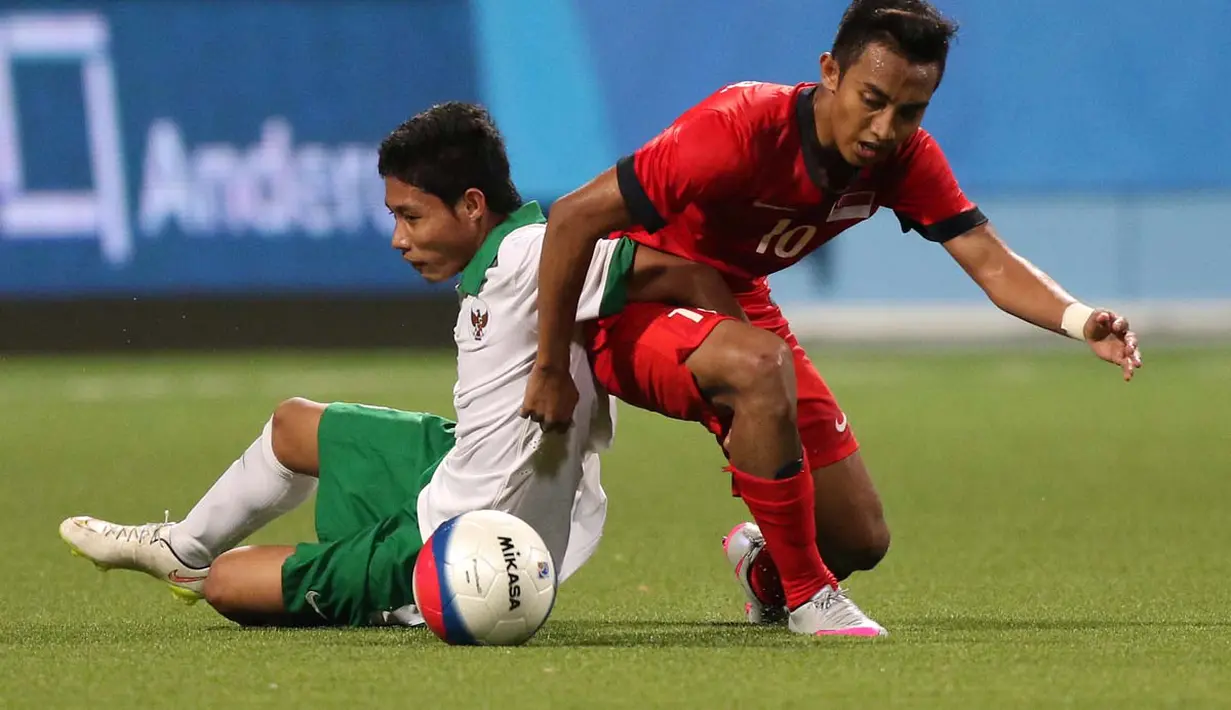 Pemain Indonesia U-23, Evan Dimas Darmono (kiri), berebut bola dengan pemain Singapura U-23, Muhammad Faris Ramli. (Bola.com/Arief Bagus)