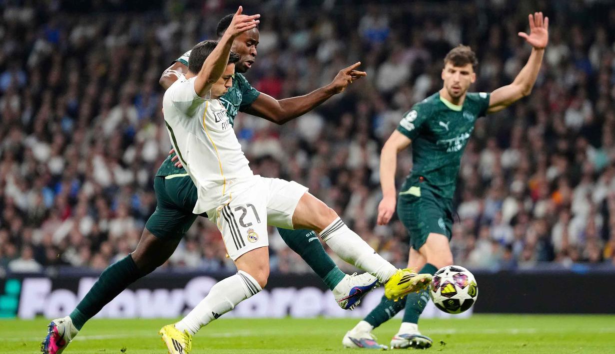 Di babak kedua, pertandingan kembali berjalan intens. Manchester City mencoba untuk mengejar defisit tiga gol di babak pertama. Tampak dalam foto, pemain Real Madrid, Brahim Diaz (depan) berebut bola dengan Marc Guehi (Manchester City) saat pertandingan leg pertama babak 16 besar Liga Champions 2025/2026 di stadion Santiago Bernabeu, Rabu 11 Maret 2026 waktu setempat atau Kamis 12 Maret 2026 dini hari WIB. (AP Photo/Jose Breton)