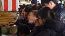 Sejumlah jemaah memanjatkan doa di Kuil Yushima Tenjin di Tokyo, Jepang (1/1). Jepang merayakan dimulainya tahun 2018, Tahun Anjing dalam zodiak Asia. (AP Photo / Eugene Hoshiko)