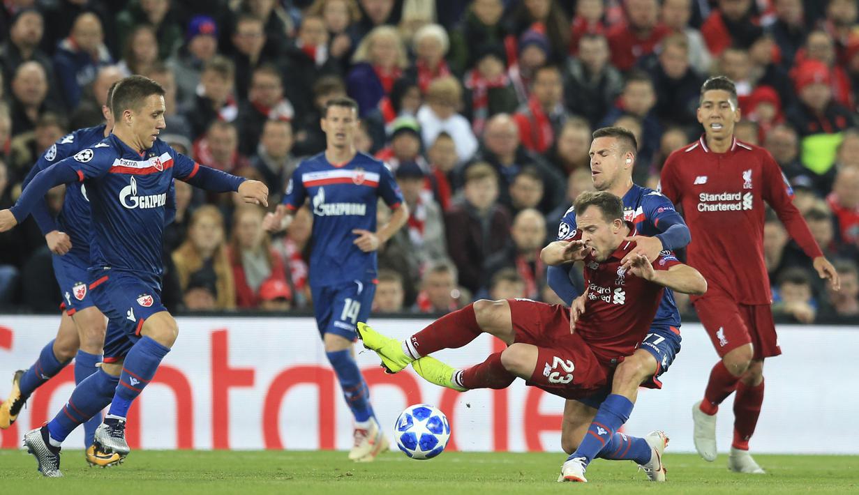 Gelandang Liverpool, Xherdan Shaqiri, terjatuh saat berebut bola dengan pemain Crvena Zvezda, Marko Marin, pada laga Liga Champions, di Stadion Anfield, Rabu (24/10/2018). Liverpool menang 4-0 atas Crvena Zvezda. (AP/Jon Super)
