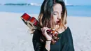 Kecintaan wanita 32 tahun ini terhadap musik membuat ia tetap membawa sebauah ukulele saat tengah berlibur. Ia juga memilih menggunakan baju bermodel off shoulder berwarna hitam dan mengurai rambutnya. (Liputan6.com/IG/@thenadiavega)