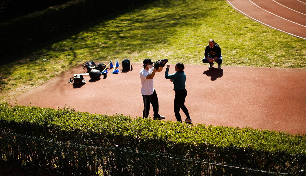 Pelatih bela diri mengenakan masker untuk mencegah penyebaran COVID-19 saat melatih murid-muridnya di Taman Cinquantenaire, Brussel, Belgia, Senin (29/3/2021). Belgia akan menutup sekolah dan membatasi akses warga ke bisnis yang tidak penting selama lockdown ketat COVID-19. (AP Photo/Francisco Seco)