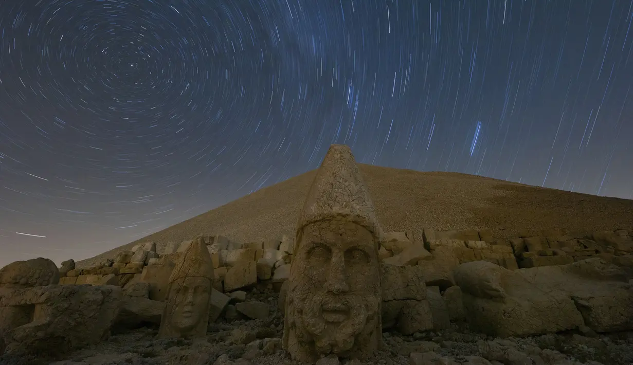 Gambar pada 23 September 2019 memperlihatkan patung-patung kepala batu berukuran raksasa di Gunung Nemrut, Provinsi Adiyaman di Turki bagian tenggara. Gunung Nemrut, telah menjadi  Situs Warisan Dunia UNESCO sejak 1987 dan merupakan salah satu Taman Nasional terpenting di Turki. (AP/Emrah Gurel)