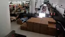 Orang-orang menunggu hasil tes virus corona mereka di tempat tidur sementara dari kotak kardus di Bandara Internasional Narita di Narita, dekat Tokyo, 8 April 2020. Di samping tempat tidur kardus, disediakan troli untuk tempat minuman dan makanan ringan, termasuk onigiri. (Naohiro Katsuta via AP)