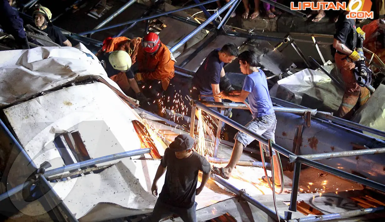 Petugas pemadam kebakaran berusaha mengevakuasi bangkai papan reklame, Selasa (22/4/14). (Liputan6.com/Faizal Fanani) 