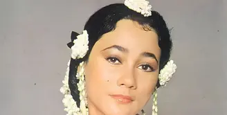 Suzzanna&nbsp; dikenal memiliki ciri khas mengenakan melati, seperti foto ini memadukan kebaya putih dengan aksesori melati di lengan dan sanggul rambutnya.&nbsp;[@suzzannaofficial]