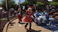 Karakter Minnie dan Mickey Mouse melambai kepada pengunjung di Disneyland Hong Kong, Kamis (18/6/2020). Disneyland Hong Kong kembali beroperasi pada 18 Juni 2020 dengan menerapkan sejumlah protokol kesehatan baru untuk mencegah penyebaran COVID-19. (AP Photo/Kin Cheung)