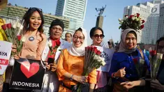 Relawan memegang bunga mawar untuk dibagikan ke pengunjung car free day di kawasan Bundaran HI, Jakarta, Minggu (30/6/2019).  Aksi 1000 bunga mawar itu sebagai bentuk rasa syukur atas kemenangan pasangan Jokowi-Ma'ruf Amin di Pilpres 2019. (Liputan6.com/Immanuel Antonius)